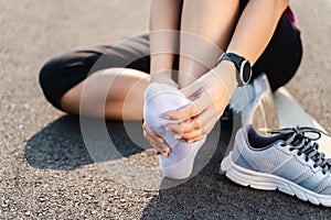 Running injury leg accident- sport woman runner hurting holding painful sprained ankle in pain. Female athlete with joint or