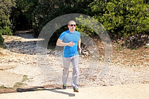 Running man athlete runner training outdoor in forest. Running runner sportsmen wearing sportswear in cross country trail run.