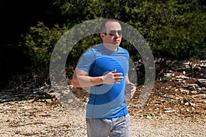 Running man athlete runner training outdoor in forest. Running runner sportsmen wearing sportswear in cross country trail run.