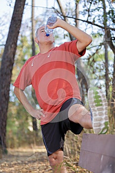 Running man drinking water