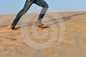 Running man on the sand in the desert as a background shot