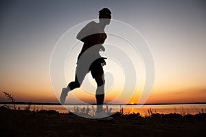 Running man silhouette in sunset time. Sport and active life concept.