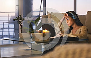 Running out of time. Cropped shot of an attractive young woman working late at night in her living room at home.