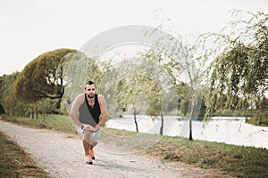 Running in the park. Active sport concept. Healthy sportsman does exercises on the street. Tired athlete in sportswear