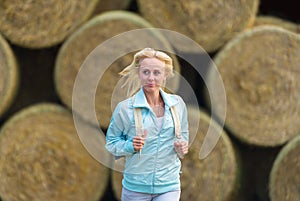 The running romantic girl outdoors against hay stack