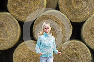 The running romantic girl outdoors against hay stack