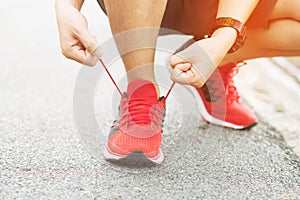 Running shoes. Barefoot running shoes closeup. male athlete tying laces for jogging on road.