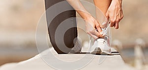 Running shoes being tied by woman