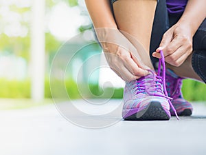 Running shoes - closeup of woman tying shoe laces.