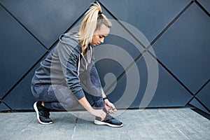 Running shoes - closeup of woman tying shoe laces. Female sport fitness runner getting ready for jogging outdoors