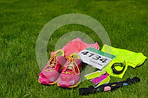 Running shoes, marathon race bib number, runners gear and energy gels on grass background, sport, fitness photo