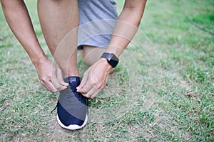 Running shoes sports smartwatch man tying shoe laces. Male fitness runner wearing technology wearable smart watch.