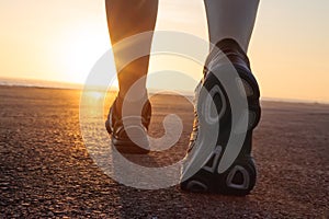 Running shoes in tarmac with sunset