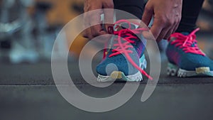 Running shoes - woman tying shoe laces in the gym