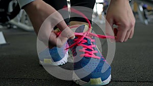 Running shoes - woman tying shoe laces in the gym