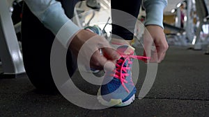 Running shoes - woman tying shoe laces in the gym