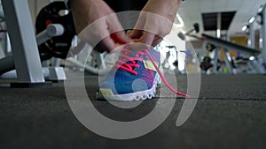 Running shoes - woman tying shoe laces in the gym