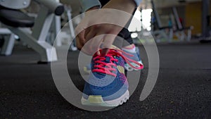 Running shoes - woman tying shoe laces in the gym