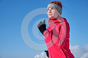 Running sport woman. Female runner jogging in cold winter forest wearing warm sporty running clothing and gloves