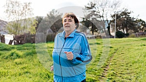 Running and sports activity. Portrait of mature happy woman in sports clothes running at the park. Concept of the International