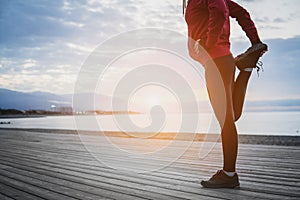 Running stretching before running. Athlete on the seacoast.