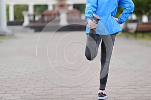 Running stretching - runner wearing smartwatch.