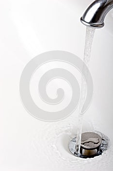 Running tap water in a sink close up