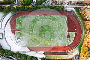Running track covered with snow. Winter cold season time. Aerial top down view