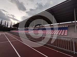 Running tracks and tribunes in the stadium in evening in winter