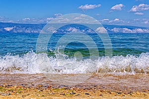 Running waves on the coast of Lake Baikal and mountains in the b