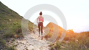 Running woman on mountain road. Sport girl exercising outside in mountains