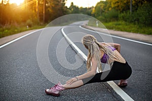 Running woman warms up before jogging on the road. Sport.