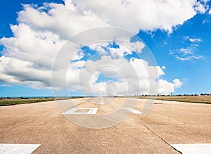 Runway, airstrip in the airport terminal with marking on blue sky with clouds background. Travel aviation concept...