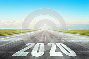 Runway asphalt road with the inscription 2020 year with blue sky. The concept of the beginning of new goals and affairs