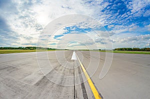 Runway clear for take off, airstrip with marking on blue sky with clouds background. Travel aviation concept