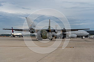 Runway with a lot of planes, including black military aircraft transall c160