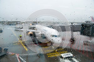 Runway and the plane through the wet glass. Abstract airport background