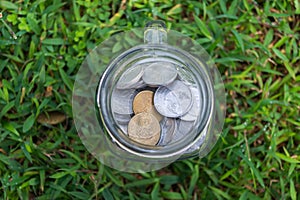 Rupiah Coin Money in jar on Green Grass Nature Background