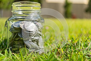 Rupiah Coin Money in jar on Green Grass Nature Background