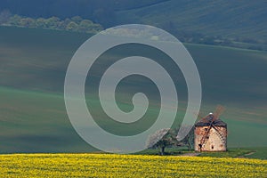 Rural abstract landscape with rolling hills and windmill in South Moravia, Czech Republic