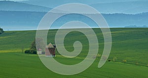 Rural abstract landscape with rolling hills and windmill in South Moravia, Czech Republic