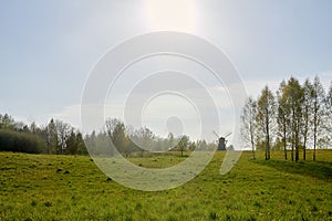 A rural area where an old mill is located in the distance