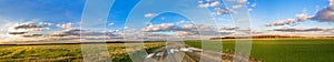 Rural autumn landscape panorama with road, field and blue sky
