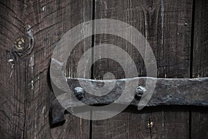 Rural background from wooden planks with knots in vertical parallel pattern texture. Wood wall facade, antique door