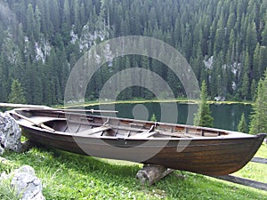Rural boat standing near mountain forest and lake. Mountain panorama