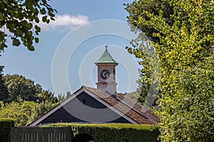 Rural building clock tower. Classic country spire in idyllic set