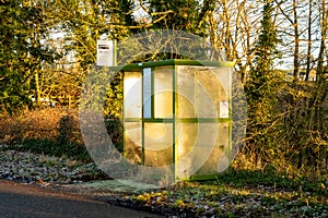 A rural bus stop beside the road at Tongland, in the low winter sun in Scotland