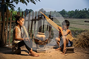 Rural children playing with blowing music and laughter. People Thailand. Boys and girls playing folk music with local instruments