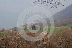 Rural contryside in mountains. Agricultural fields on hills with Iseo lake on background