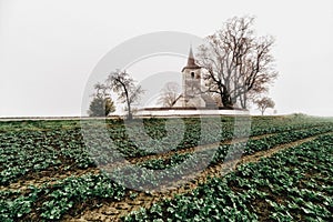 Rural country with blurred car motion and gothic church in Ludrova village in Slovakia